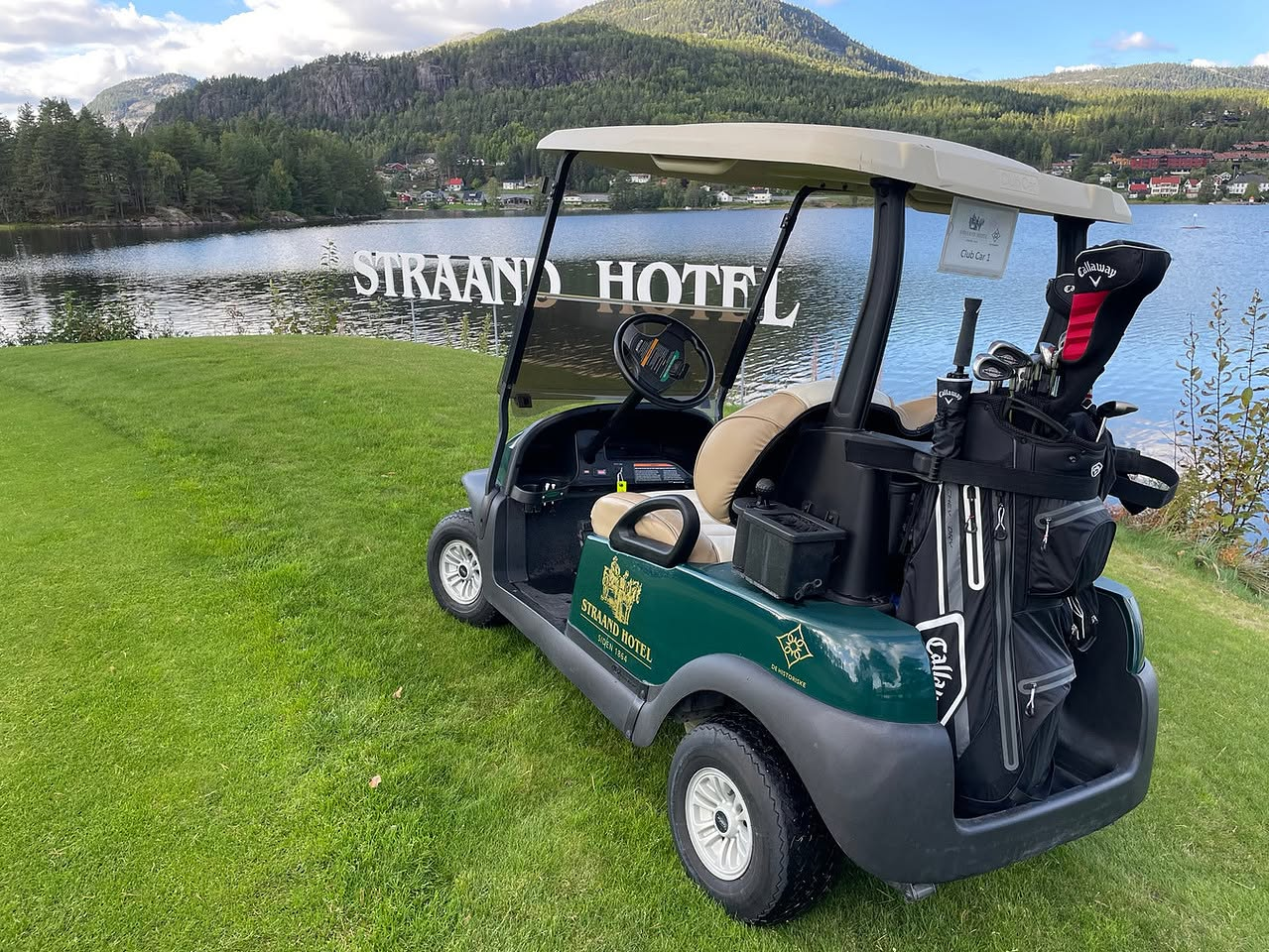 Golfbil med Straand Hotel-profilering ved innsjøen på Vrådal Golf